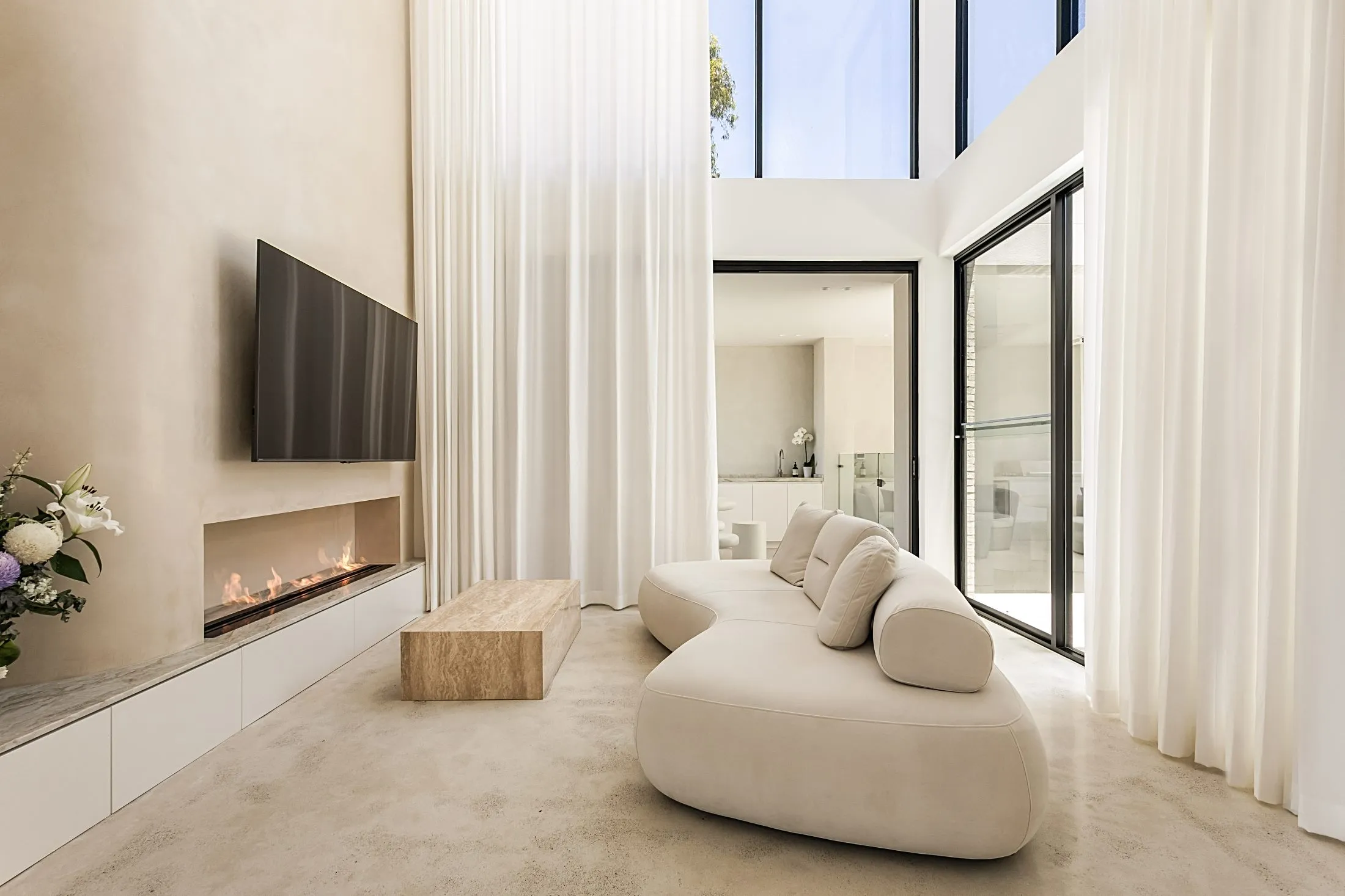 Double-height living room with a built-in linear fireplace and long white joinery unit, Lilyfield