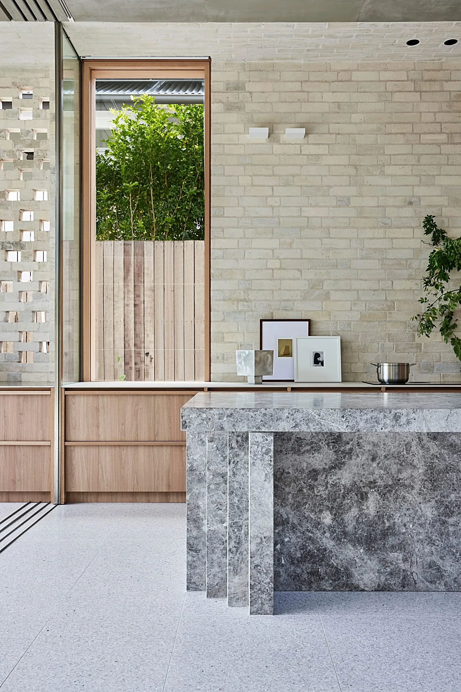 Stone kitchen island and timber base cabinets against a brick wall, Freshwater
