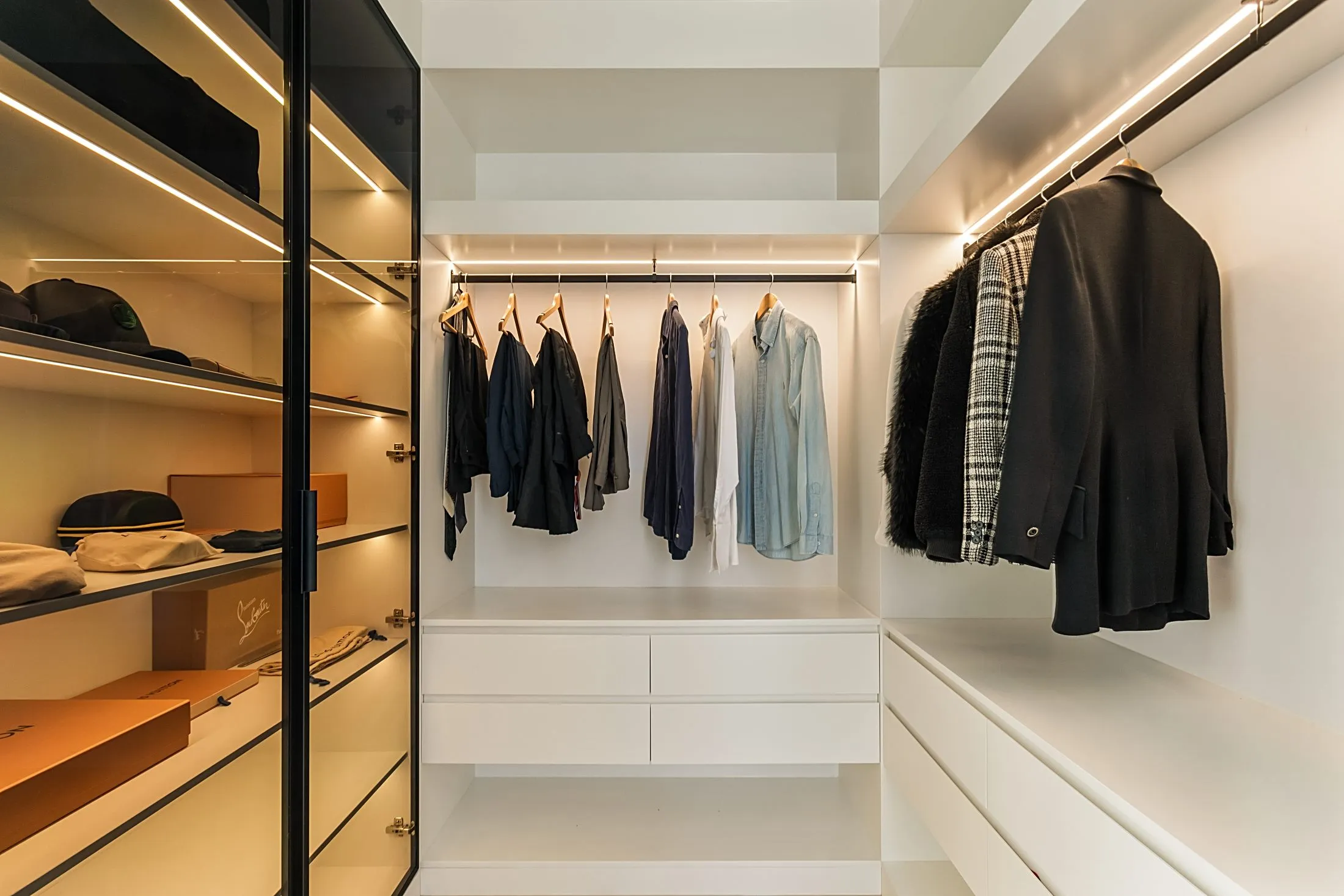 Walk-in wardrobe with black-framed glass doors, LED-lit shelving and drawers, Lilyfield